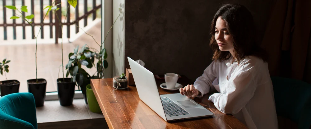 Profissional em trabalho híbrido usando notebook em espaço de trabalho flexível