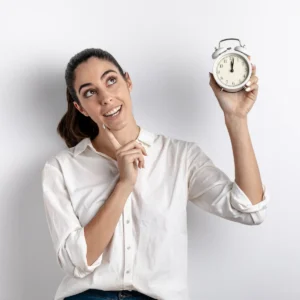 Mulher sorridente segurando um relógio marcando meia-noite, simbolizando horas extras no trabalho.