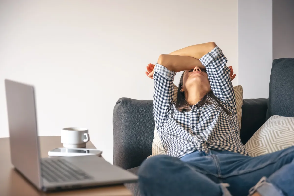 Mulher cansada em frente ao laptop representando os sinais de burnout — como medir burnout no trabalho